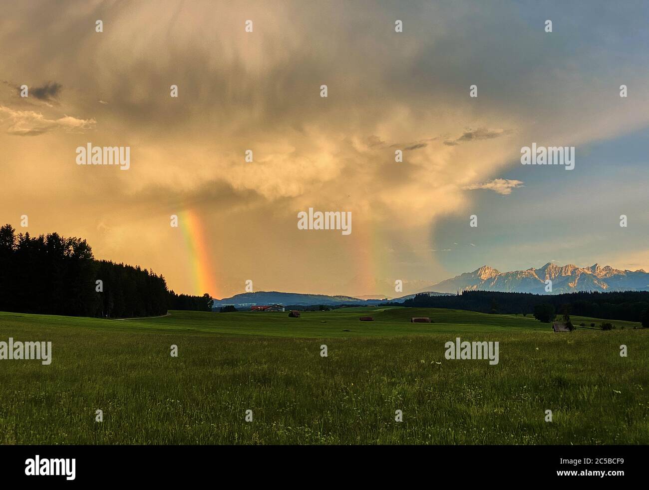 Marktoberdorf, Germany, July 01, 2020.  Stormy weather with heavy rain changes with sunset and rainbow. © Peter Schatz / Alamy Stock Photos Stock Photo
