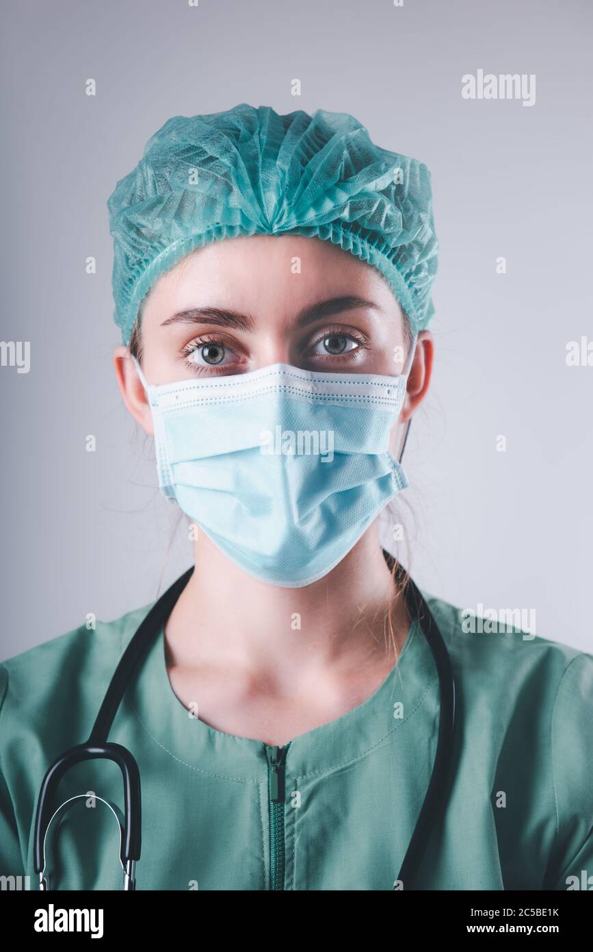 Female Doctor in Protective Mask and Medical Cap on Isolated Background,  Closeup Portrait of Medicine Surgeon Doctor Wearing Medical Mask With  Stethos Stock Photo - Alamy