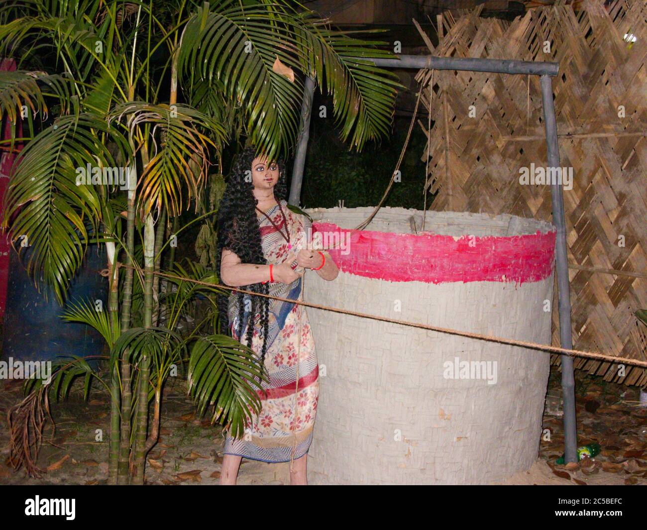 clay made village girl taking water from well made by tribes of bengal