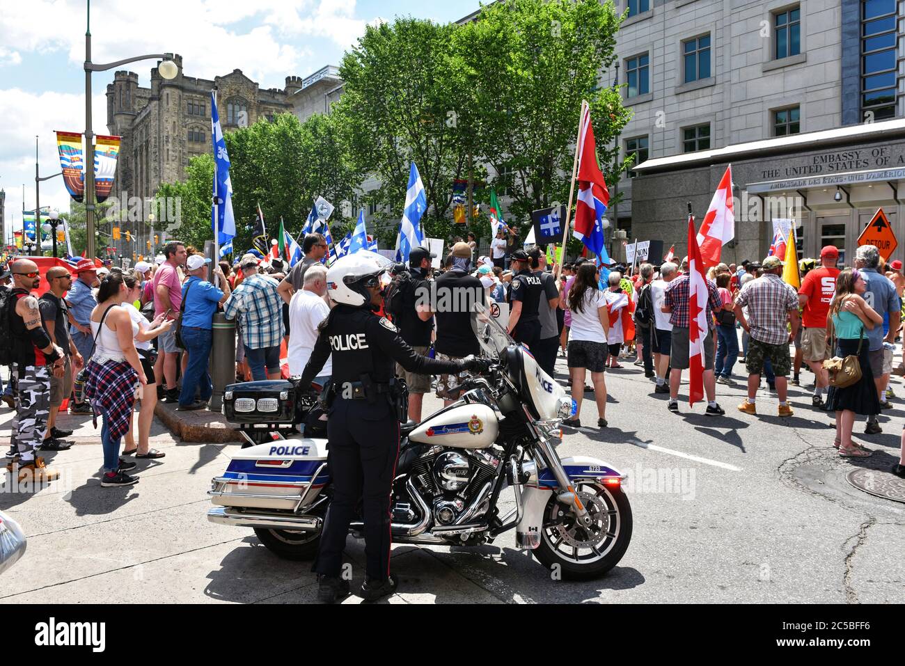 Ottawa, Canada - July 1, 2020: Protesters and counter protesters gather in front of the US Embassy. The annual Canada Day festivities were cancelled due to the Coronavirus pandemic. Stock Photo