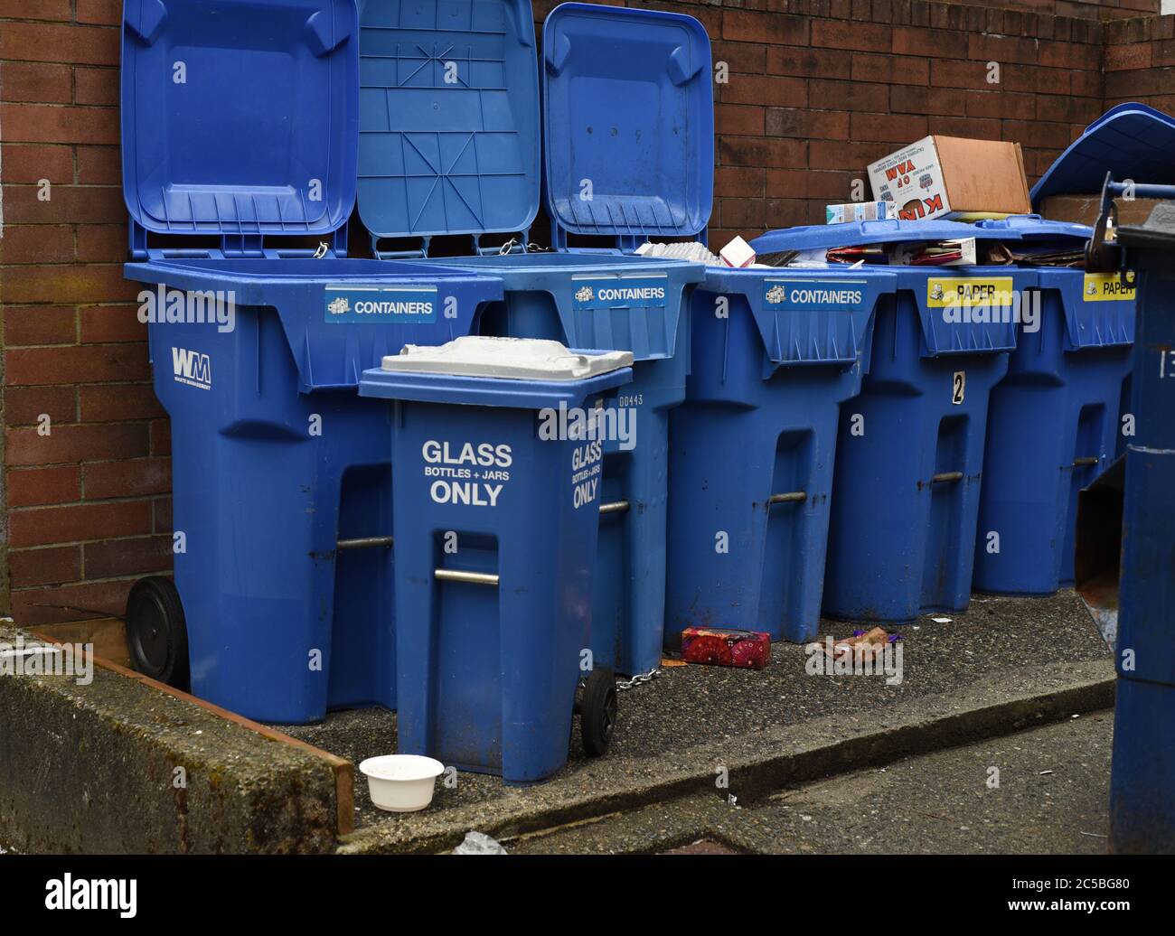 Containers for garbage and for recycling items such as glass and paper in a back alley in Vancouver, British Columbia, Canada Stock Photo