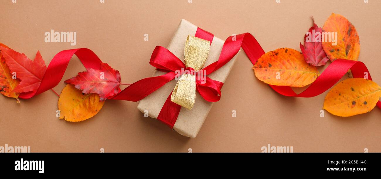 Autumn creative holiday present. Handmade paper gift box with satin bow ...