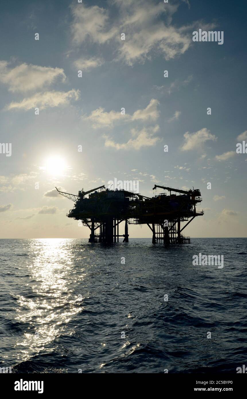 View of oil and gas rigs in the Gulf of Thailand. Numerous wellheads are situated in the gulf, drilling wells are built off shore to explore underwater crude oil, fuel oils, natural gas, liquefied petroleum gas and petrochemicals. Stock Photo