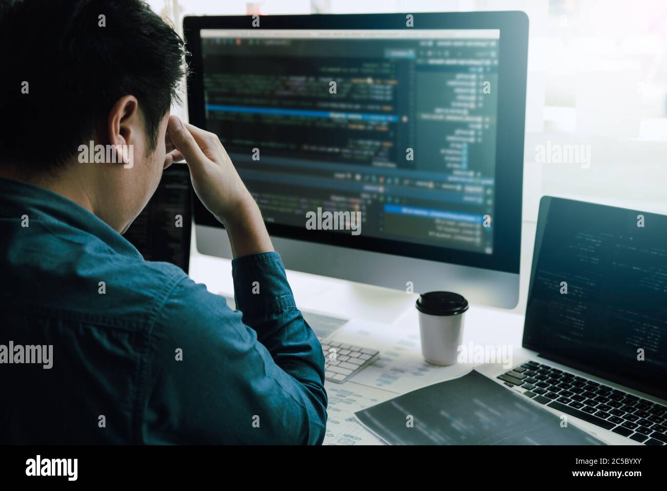 Software developers headache with code analysis in the office. Stock Photo