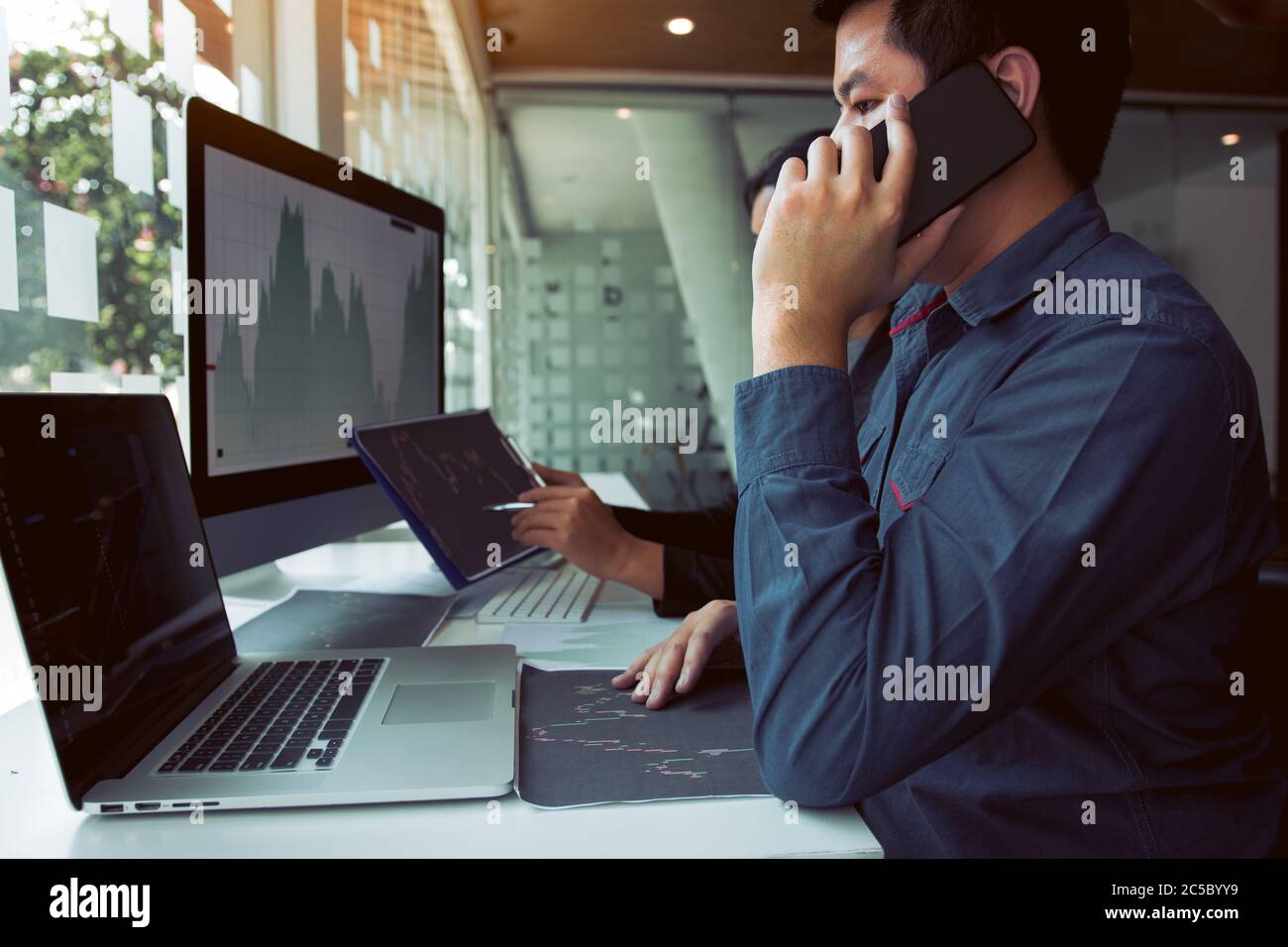 Two asian agent man working and analysis together in office market ...