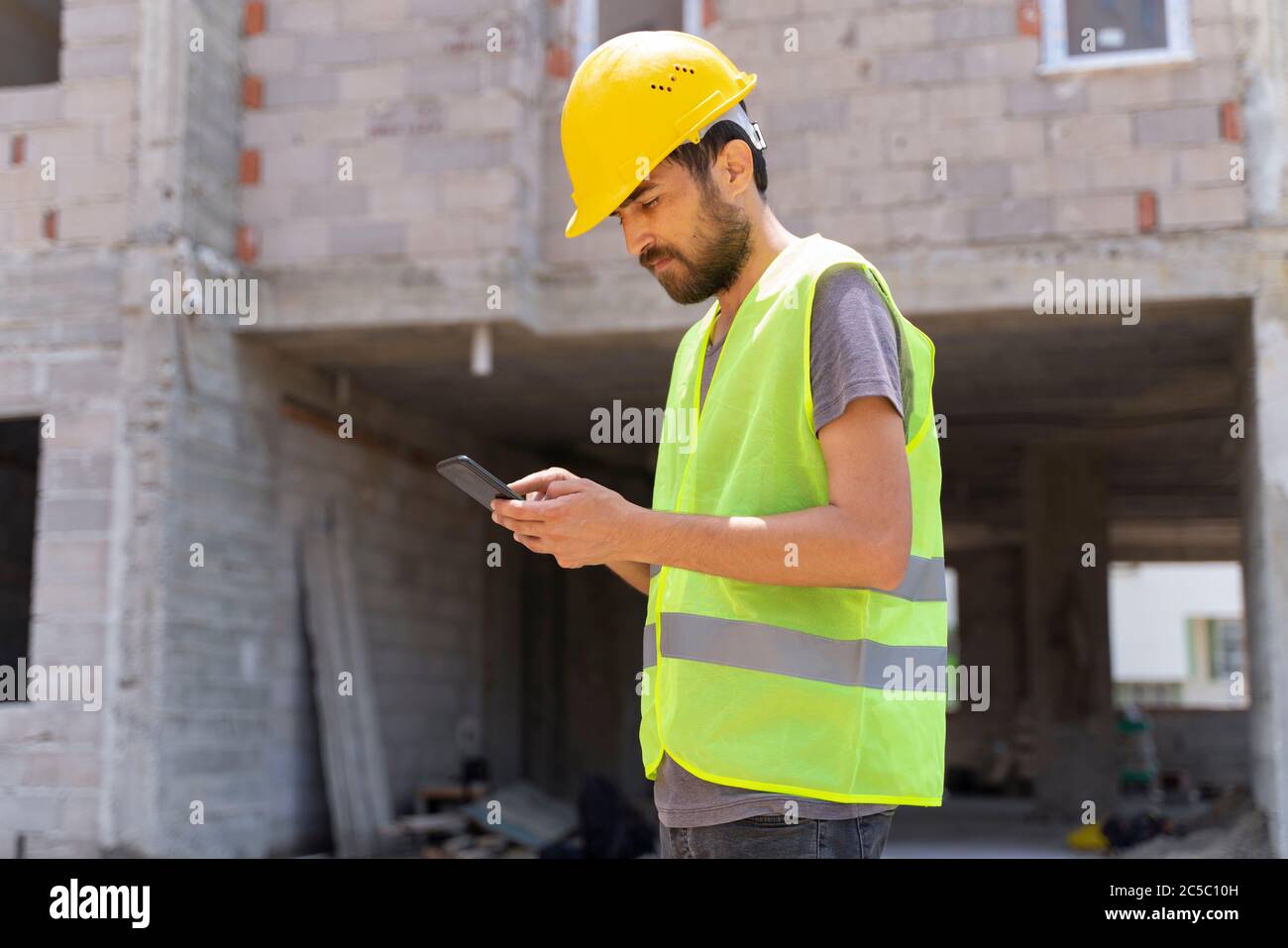 Young carpenter is using mobile phone at carpentry shop Stock Photo