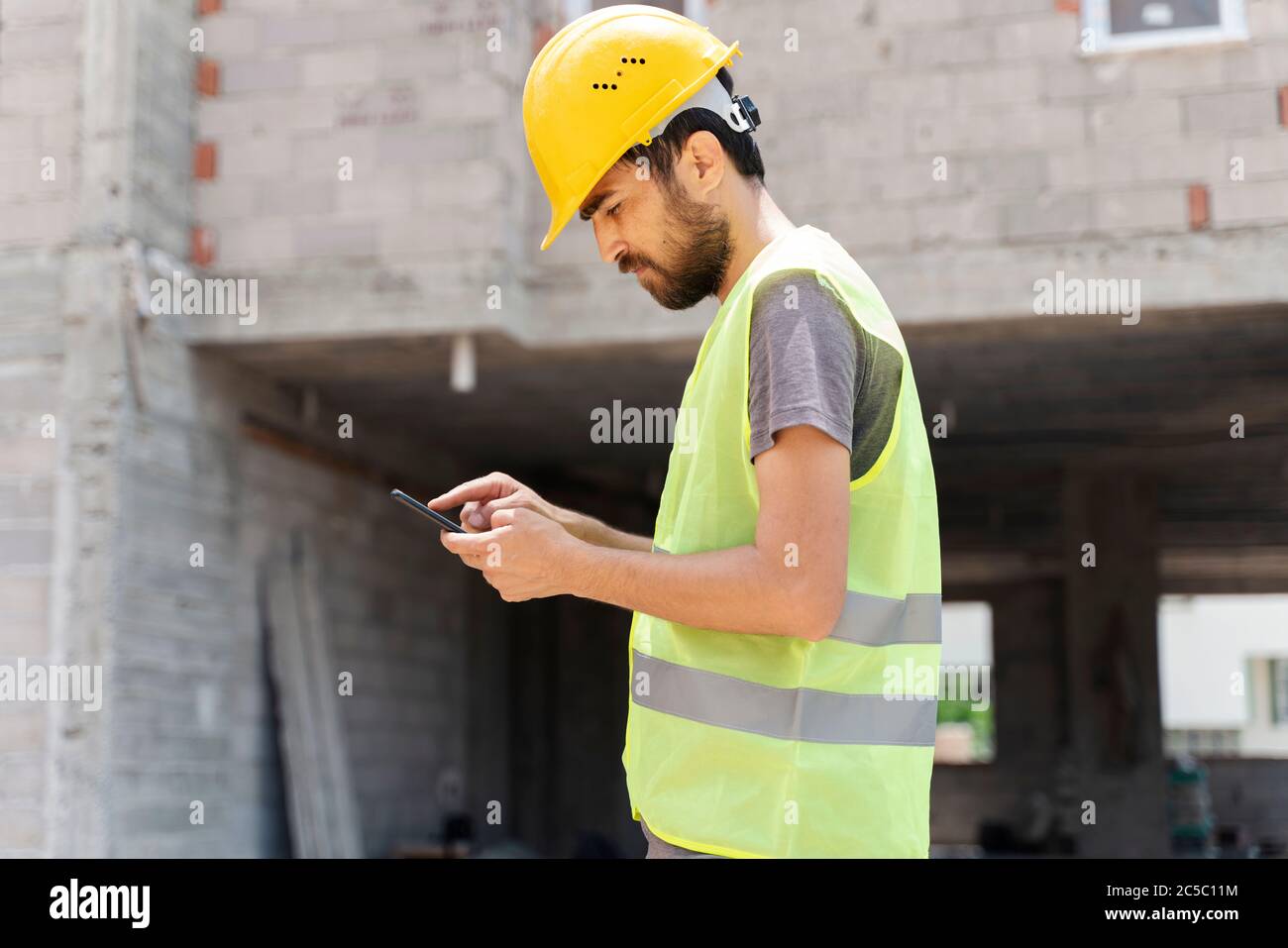 builder with van checking text messages on mobile phone Stock Photo