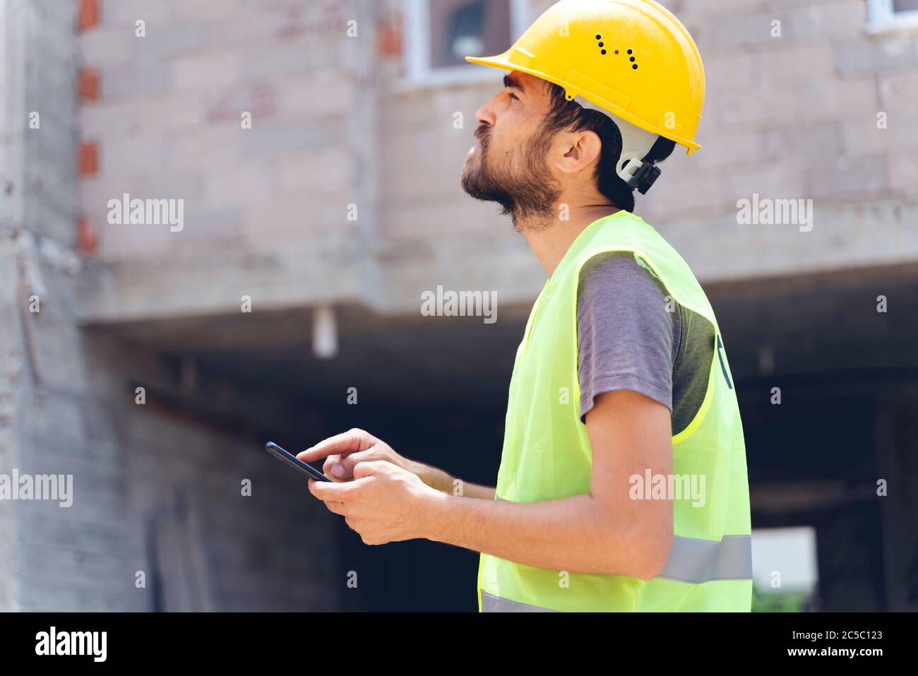 builder with van checking text messages on mobile phone Stock Photo