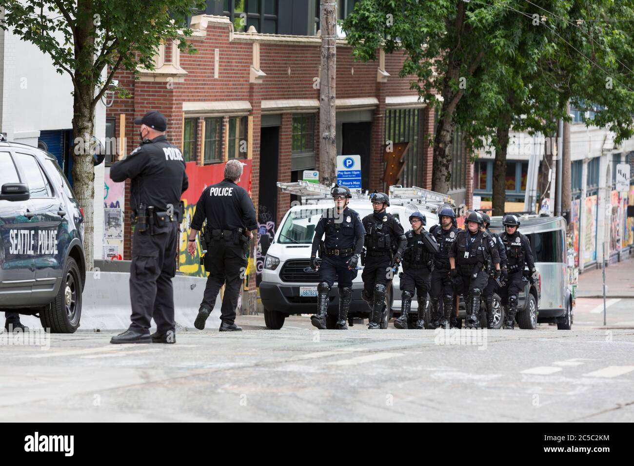Washington DC, USA. 1st July 2020. Police officers in riot gear arrive at the closed East Precinct after clearing the 'Capitol Hill Occupied Protest' zone in Seattle on Wednesday, July 1, 2020. The zone, an occupation protest and self-declared autonomous zone, was established on June 8, 2020 when the Seattle Police Department closed the East Precinct after days of protests in the wake of the death of George Floyd while in Minneapolis police custody Credit: Paul Christian Gordon/Alamy Live News Stock Photo