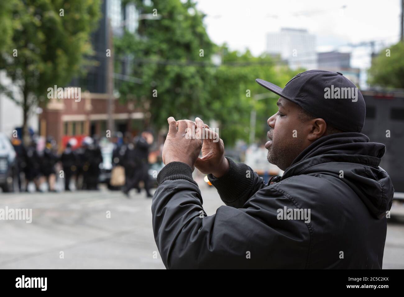 Washington DC, USA. 1st July 2020. Seattle journalist Omari Salisbury livestreams from the closed East Precinct after police officers cleared the 'Capitol Hill Occupied Protest' zone in Seattle on Wednesday, July 1, 2020. The zone, an occupation protest and self-declared autonomous zone, was established on June 8, 2020 when the Seattle Police Department closed the East Precinct after days of protests in the wake of the death of George Floyd while in Minneapolis police custody. Credit: Paul Christian Gordon/Alamy Live News Stock Photo