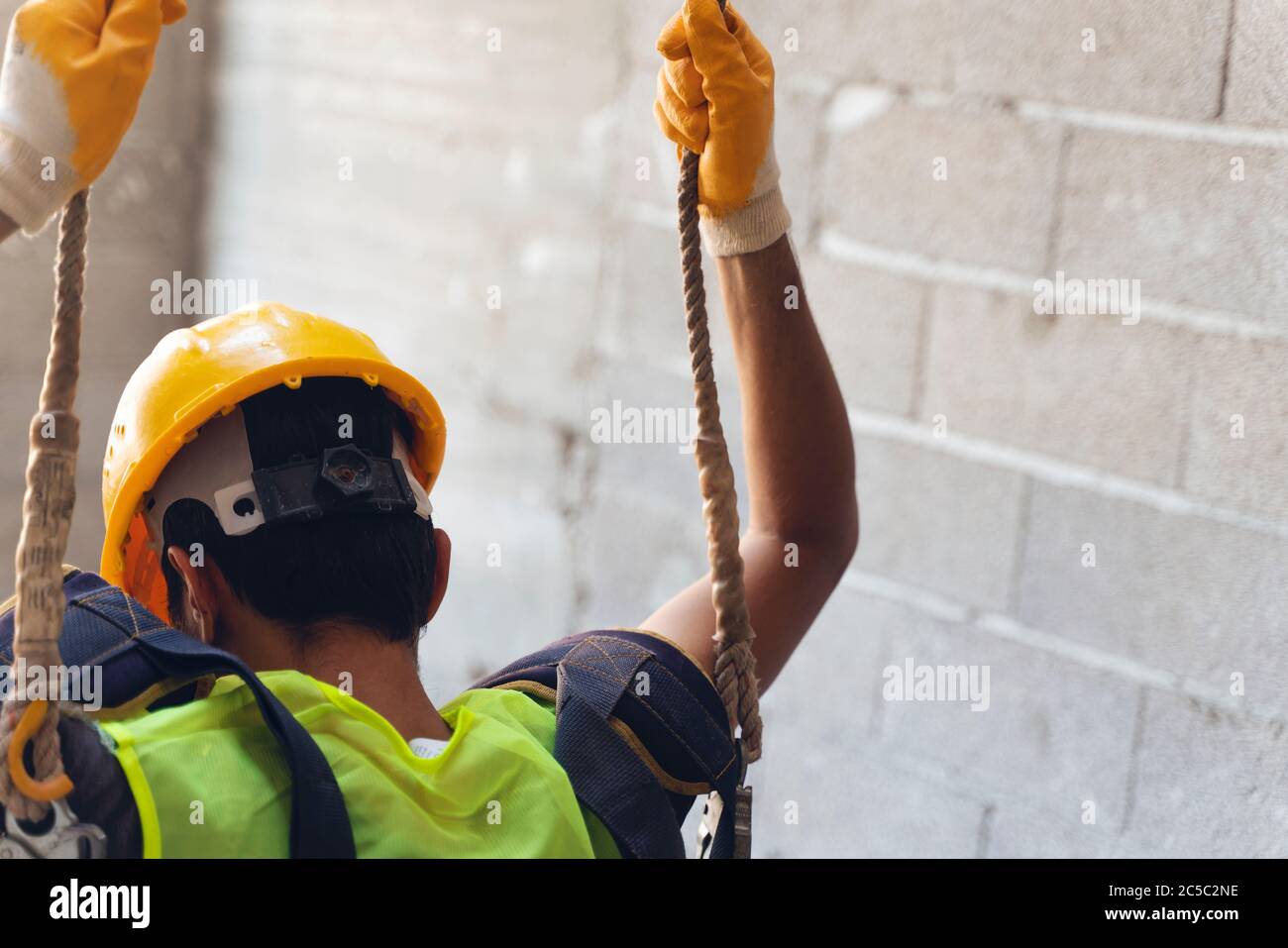 Working at height equipment. Fall arrestor device for worker with double hooks for safety body harness on selective focus. Construction as a backgroun Stock Photo