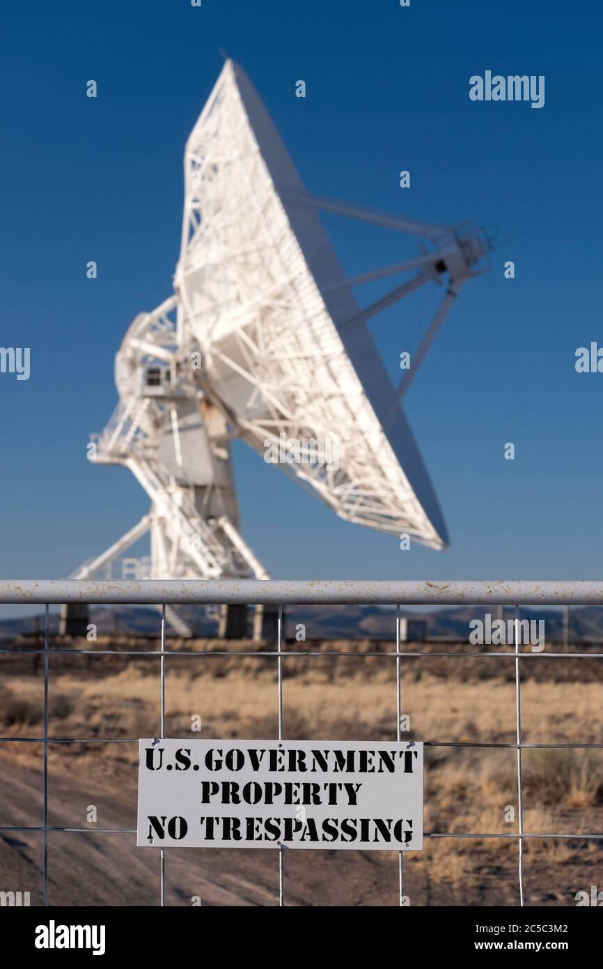 Radio telescope dish at the very large array with a government property warning no trespassing sign Stock Photo