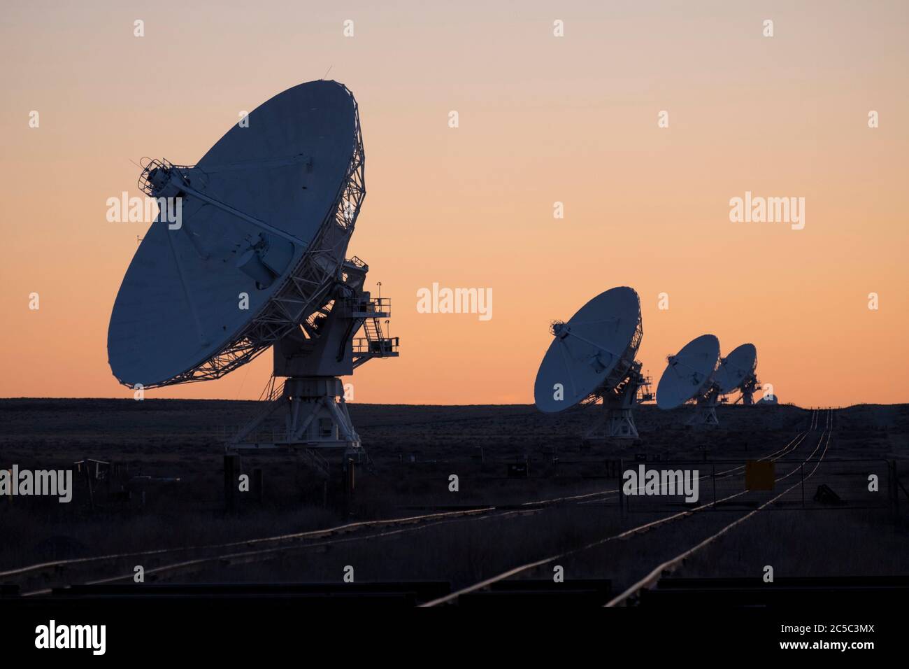 Row of radio antennas after sunset at the VLA in New Mexico Stock Photo