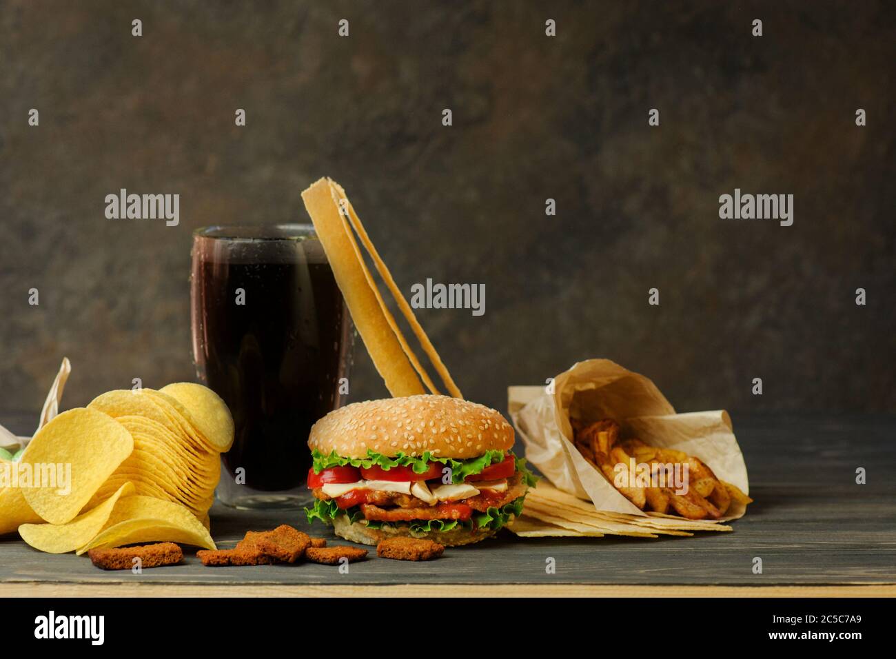 Fast food and snack concept. Unhealthy nutrition hamburger, potato fries and cola. Stock Photo