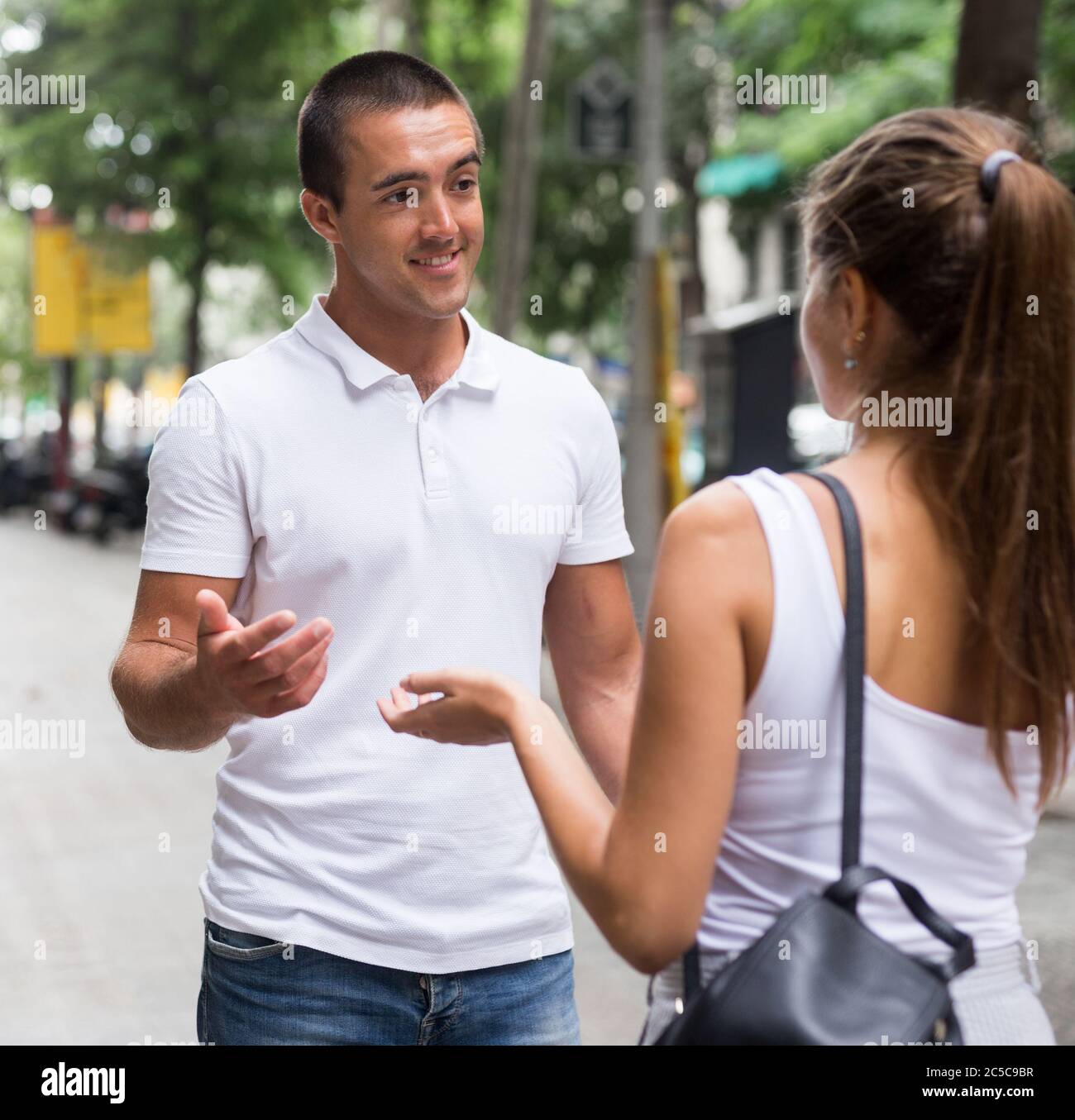 Young man and woman talking emotionally on street Stock Photo - Alamy