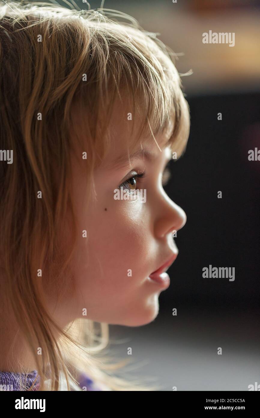 image of a child from profile while looking cartoon, note shallow depth of field Stock Photo