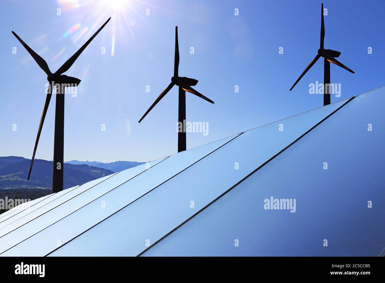 Symbolbild Energiewende: Solardach mit Windkraftanlagen im Hintergrund (Composing) Stock Photo