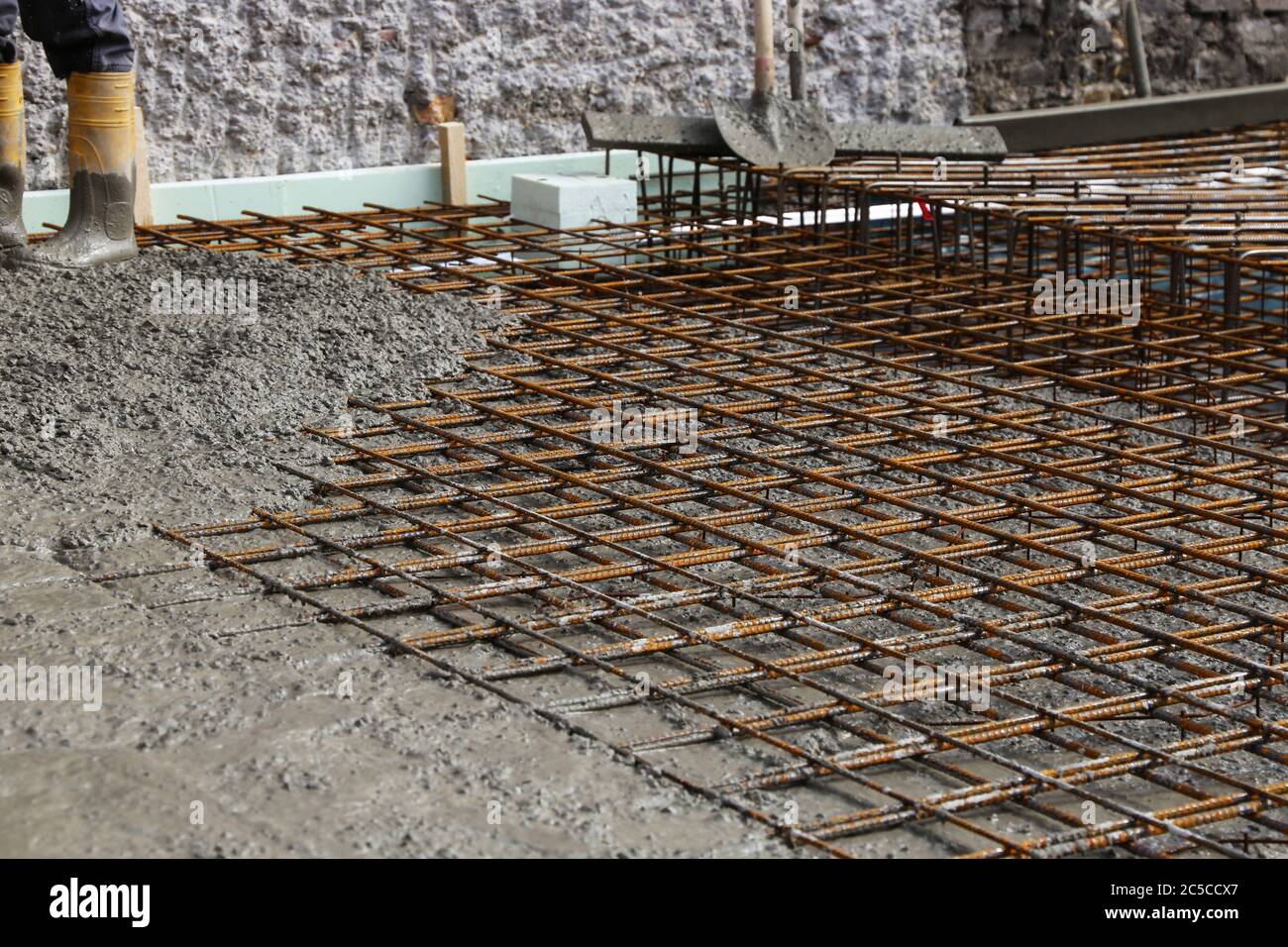 Betonieren einer Bodenplatte mit Fertigbeton bzw. Transportbeton auf der Baustelle eines Wohnhauses Stock Photo