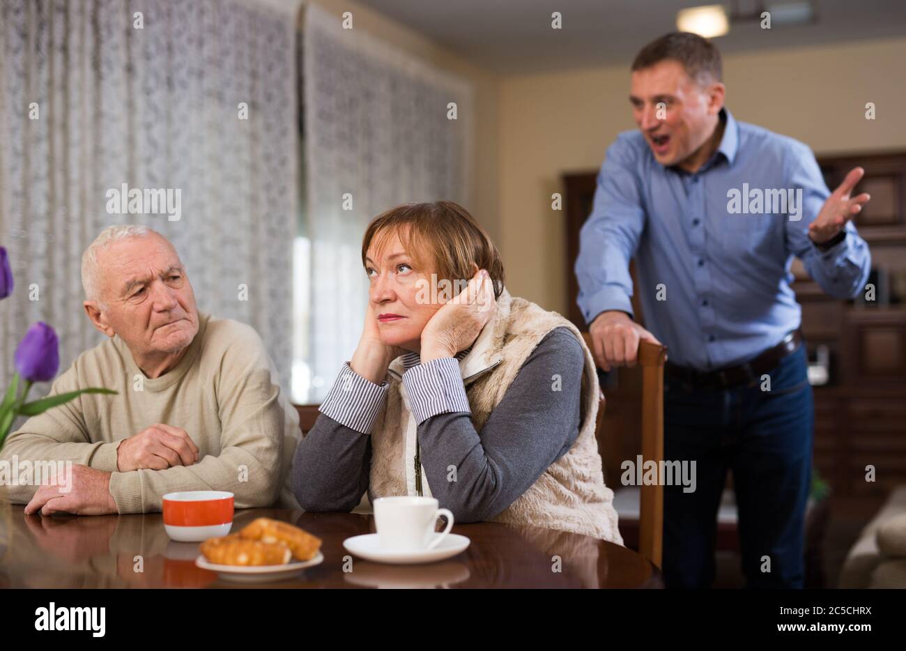 Adult annoyed man scolding his senior parents at home Stock Photo - Alamy