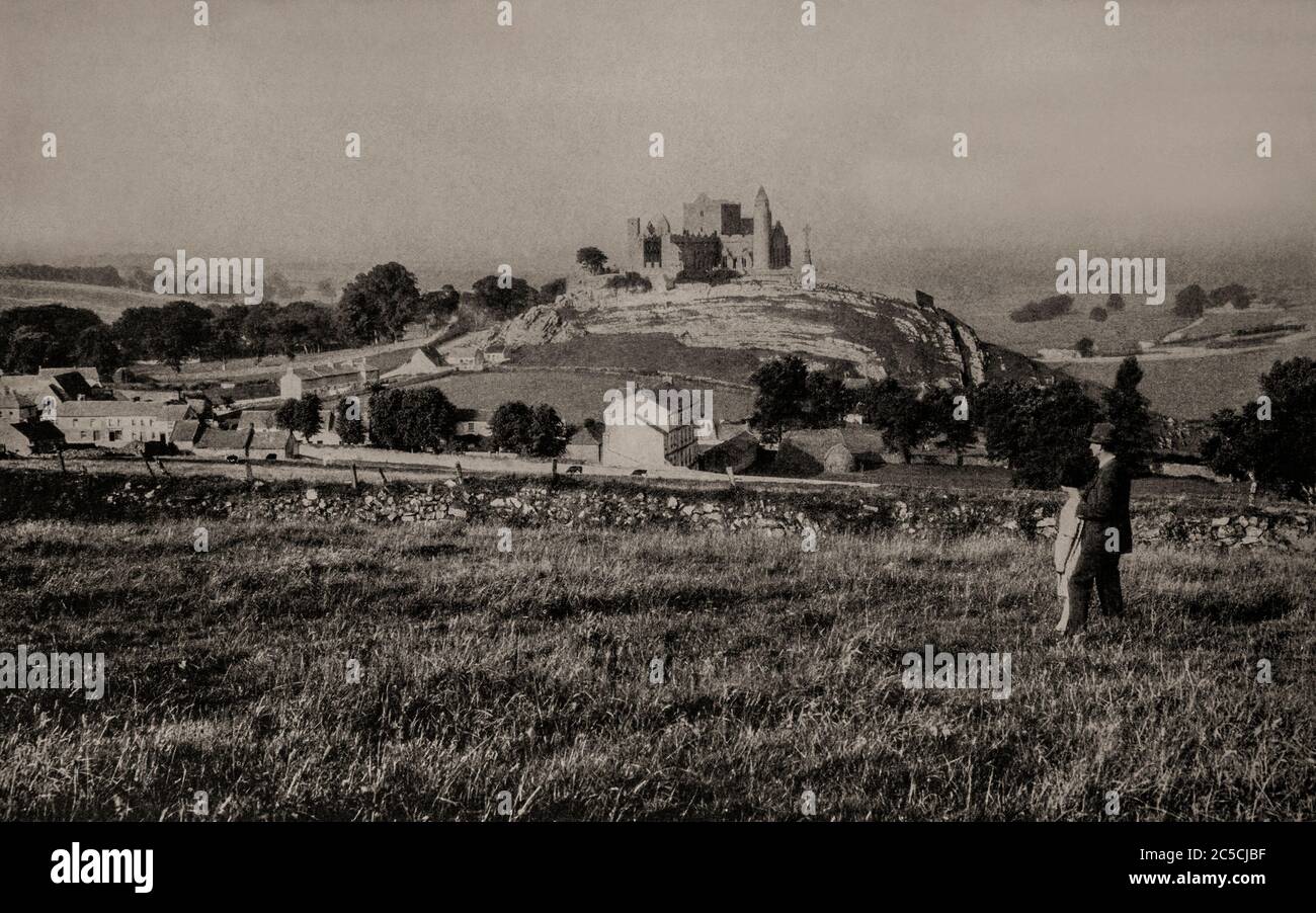 An early 1920's view of the Rock of Cashel, also known as Cashel of the Kings and St. Patrick's Rock. A historic site located at Cashel, County Tipperary, it was reputed to be the site of the conversion of the King of Munster by St. Patrick in the 5th century. Traditional seat of the kings of Munster for several hundred years prior to the Norman invasion until 1101, Muirchertach Ua Briain, King of Munster donated the fortress to the Church. Originally photographed by Clifton Adams (1890-1934) for 'Ireland: The Rock Whence I Was Hewn', a National Geographic Magazine feature from March 1927. Stock Photo