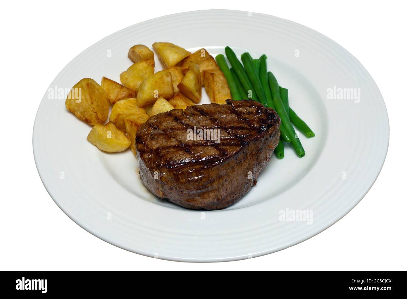 Fillet steak with green beans and saute potatoes on a white plate against an isolated white background with a clipping path Stock Photo