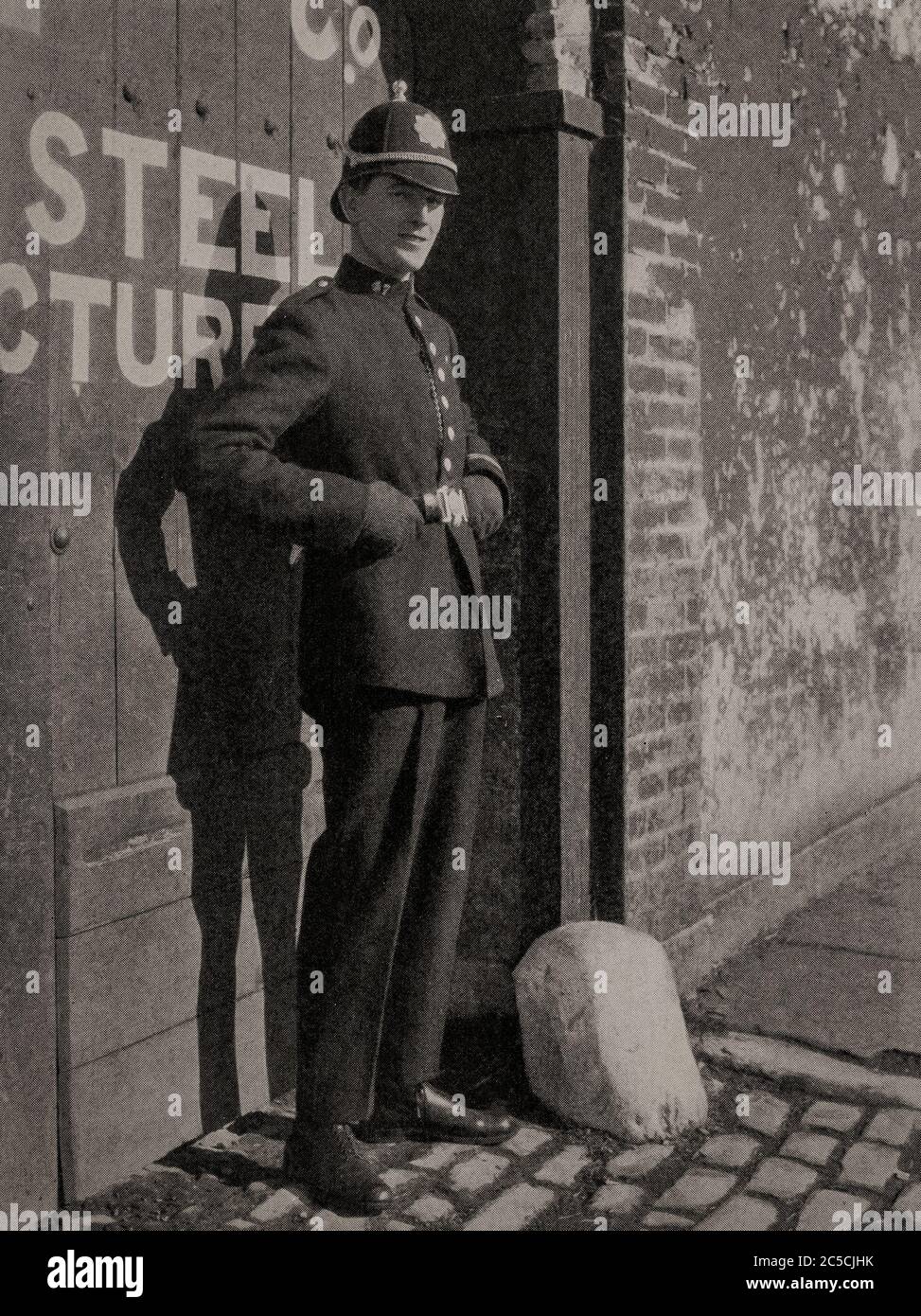 An early 1920's portrait of  a member of the Garda Siochana (police), complete with helmet in Cork City. Originally photographed by Clifton Adams (1890-1934) for 'Ireland: The Rock Whence I Was Hewn', a National Geographic Magazine feature from March 1927. Stock Photo