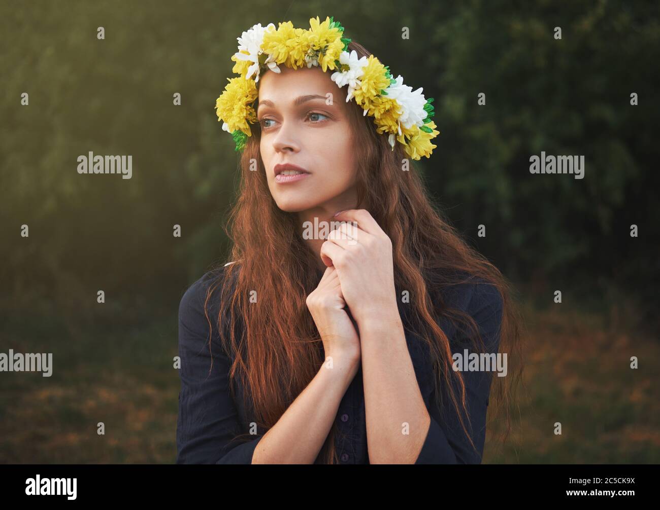 Outdoor portrait of a beautiful girl is wearing a flower wreath on head ...