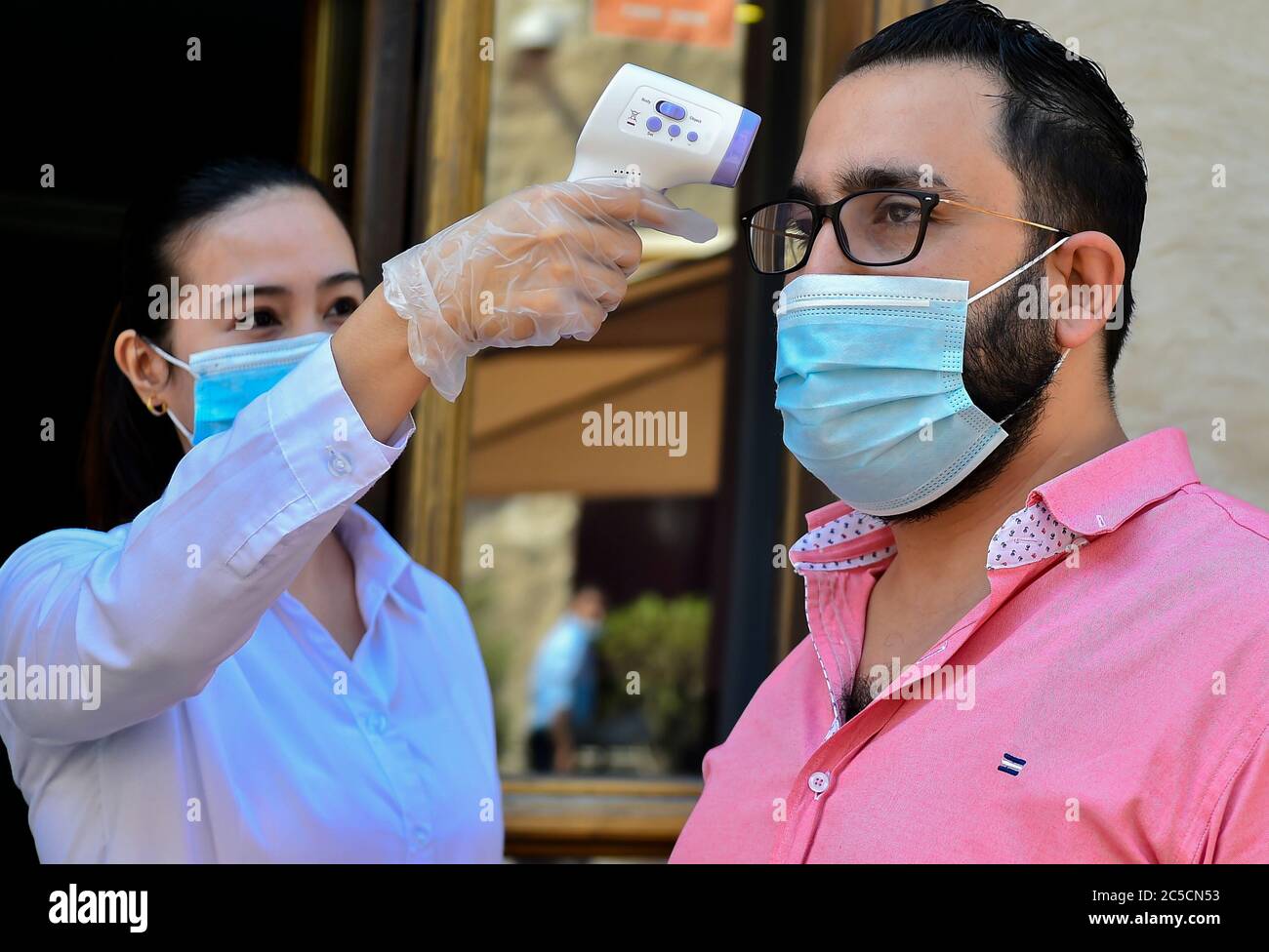 Doha, Qatar. 1st July, 2020. A staff member measures a customer's body temperature at the entrance of a restaurant at Souq Waqif market in Doha, capital of Qatar, on July 1, 2020. Credit: Nikku/Xinhua/Alamy Live News Stock Photo