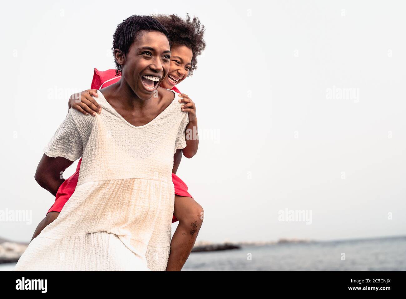 Happy African family on the beach during summer holidays Afro