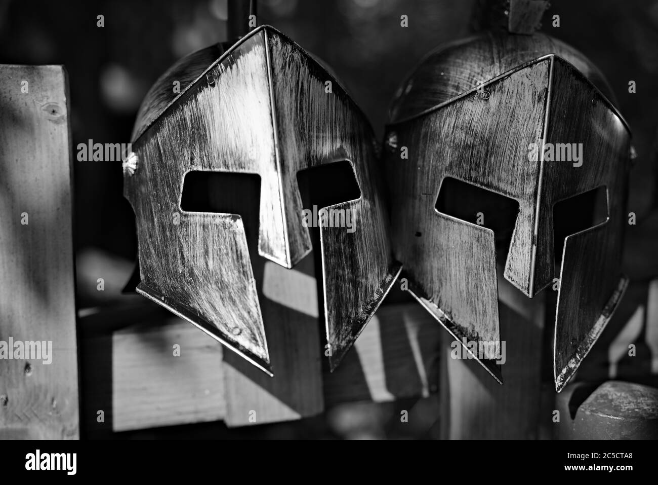 Shiny silver and brass fake historical knight helmets used as a decoration on a hedge on parking lot nearby Orava castle. Stock Photo