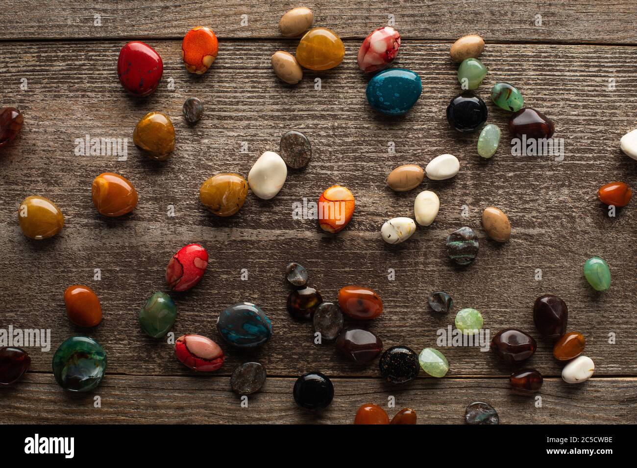 Top view of colorful fortune telling stones on wooden surface Stock