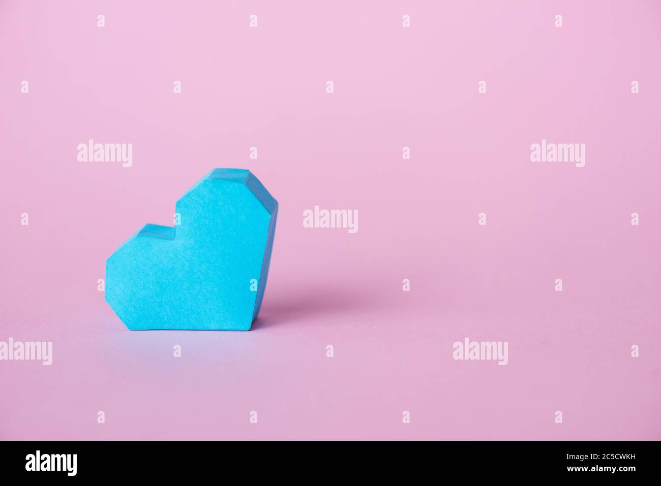 blue origami heart on pink with copy space Stock Photo - Alamy
