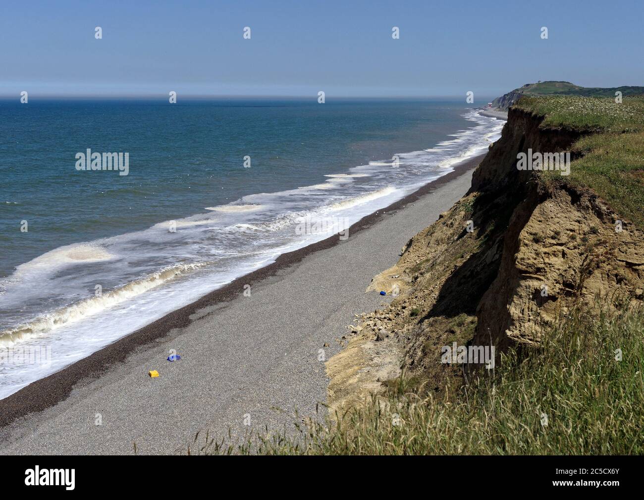 View east along the eroding clay cliffs of Norfolk towards Sheringham showing the rapidly eroding boulder clay cliff and shingle beach. Stock Photo