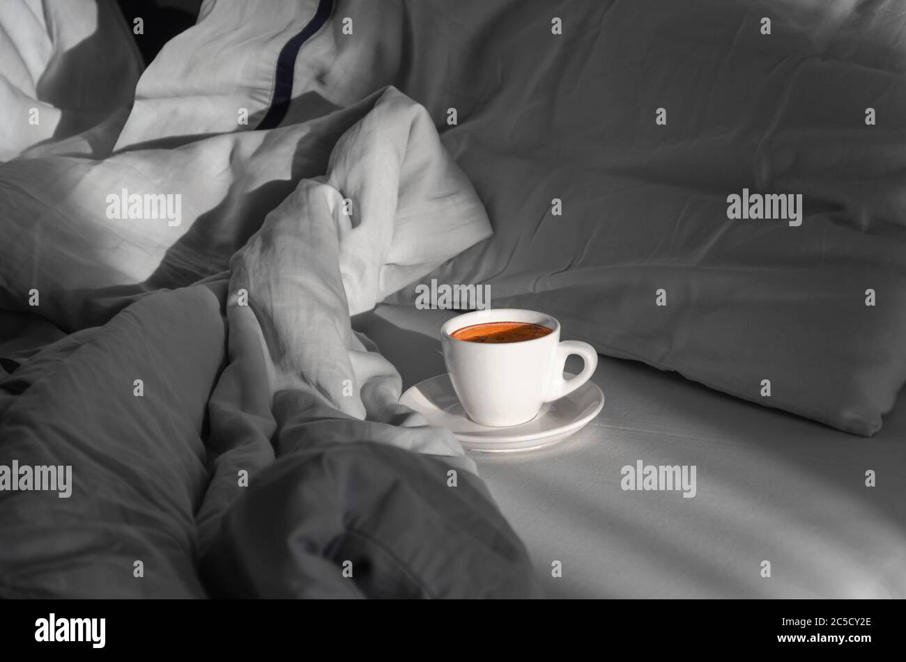 Morning coffee in bed. Cup of coffee on the bed in the room with a lot of natural sunlight. Morning concept. Enjoying the little things Stock Photo