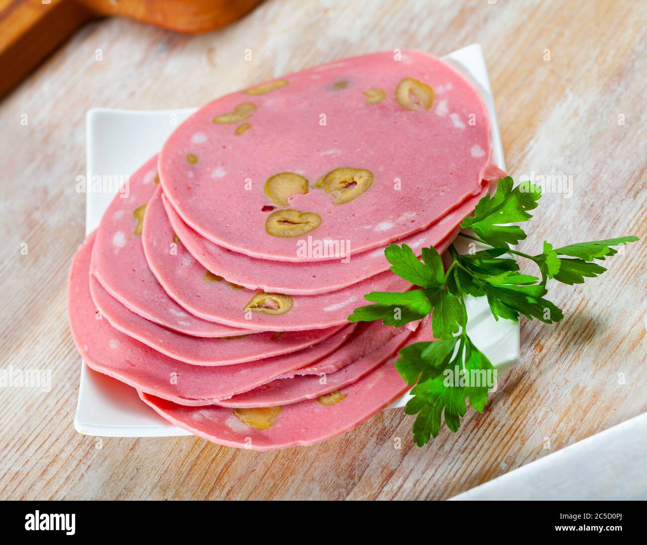 Sliced Mortadella sausage from finely ground pork seasoned with olives