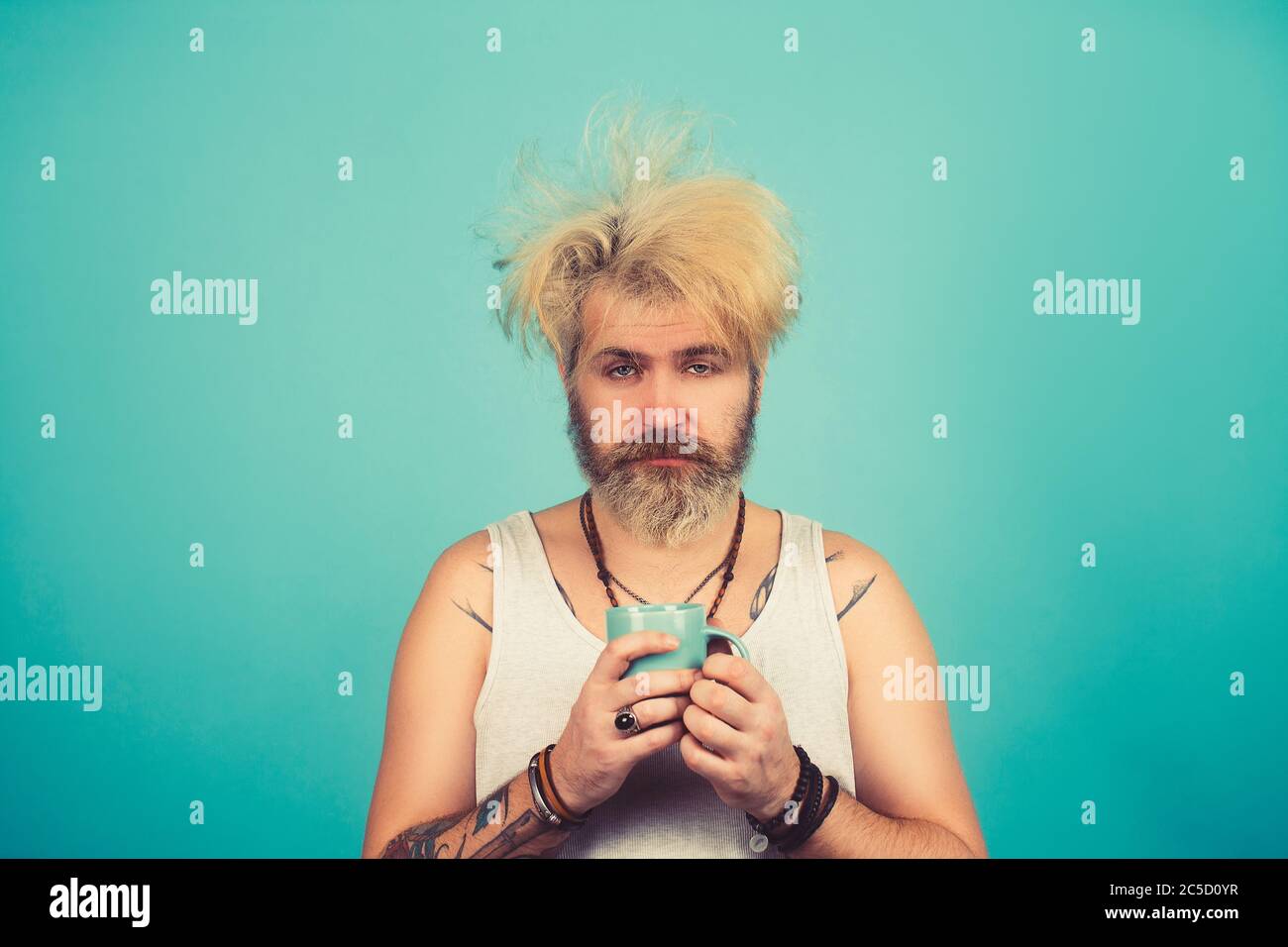 Concept of having headache after global party. In the morning sleepy man with coffee Stock Photo