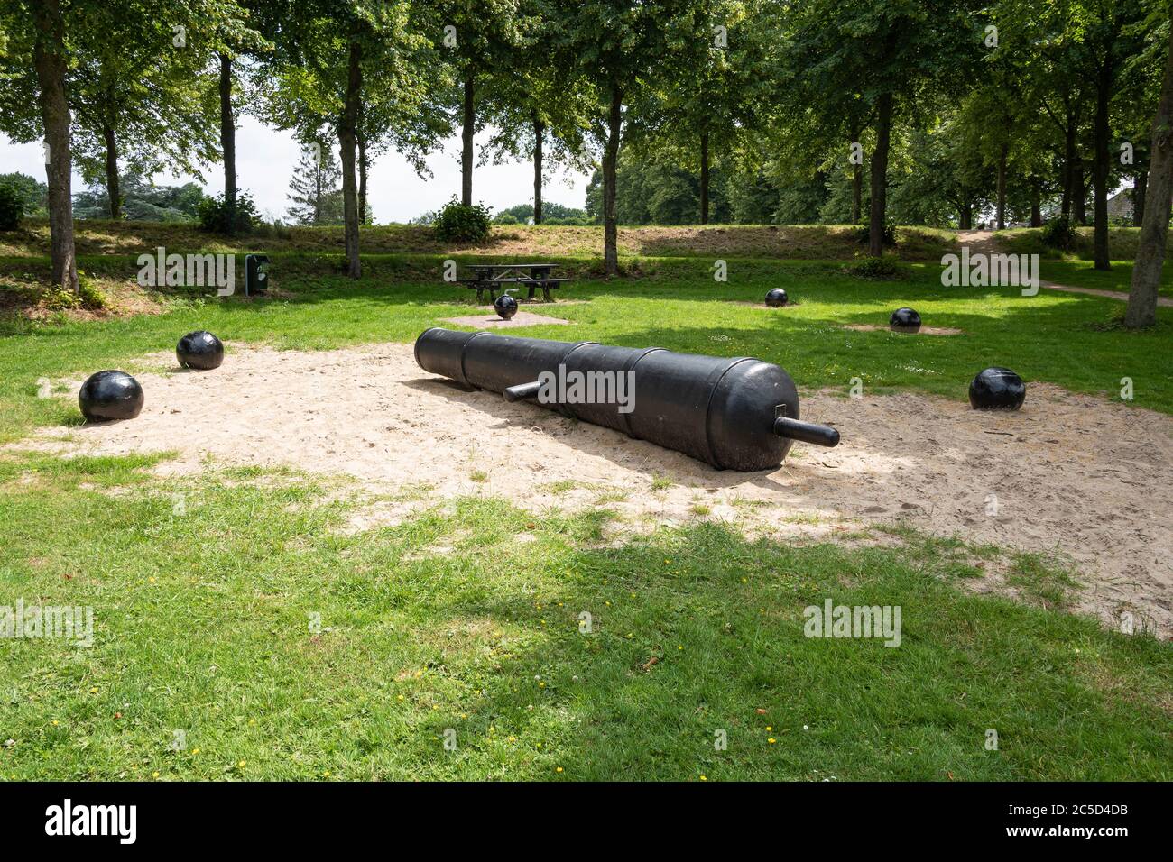 The barrel of a cannon with cannon balls around it Stock Photo