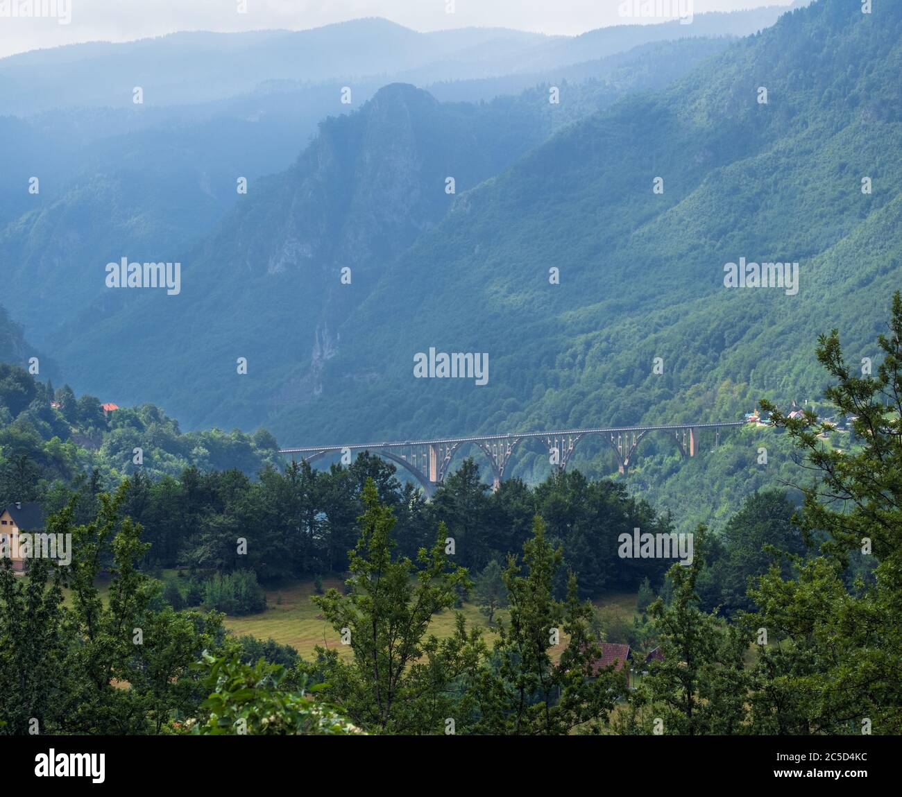 Summer misty mountain landscape with bridge(Tara Canyon, Montenegro). Stock Photo