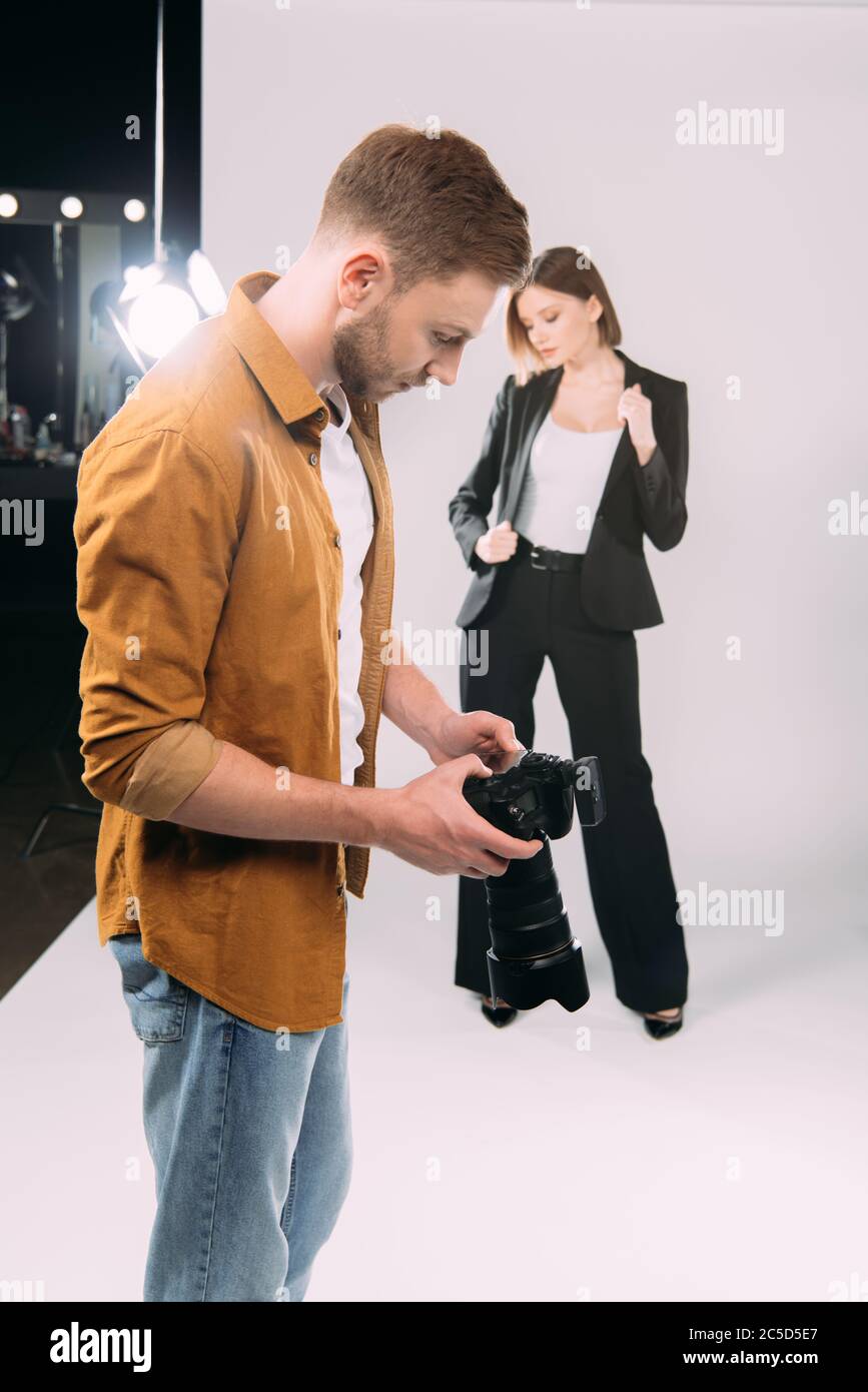Selective focus of photographer looking at display of digital camera ...