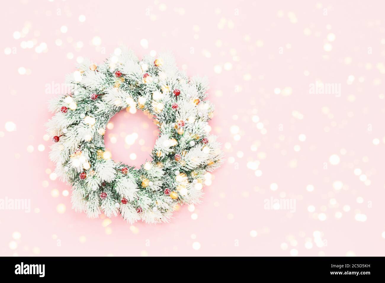 Christmas background. White Christmas wreath with decoration on pink background. New Year concept. Copy space, top view Stock Photo