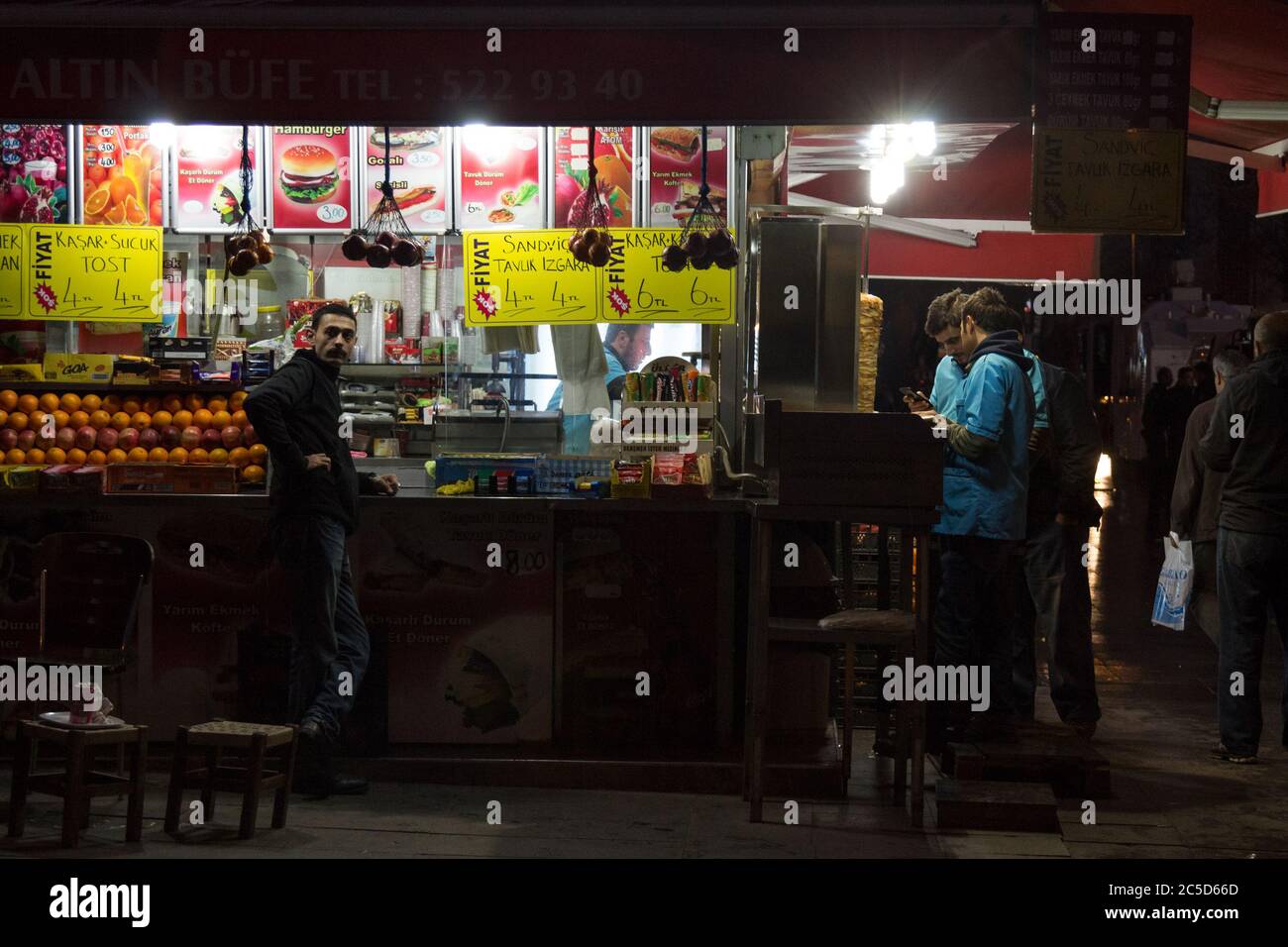 ISTANBUL, TURKEY - DECEMBER 29, 2015: People standing and eating turkish food in front of a Bufe, a typical street food stand of the streets of Istanb Stock Photo