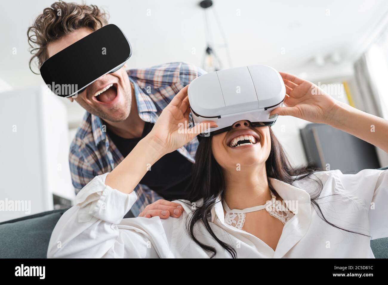 Cheerful couple using virtual reality headsets at home Stock Photo - Alamy