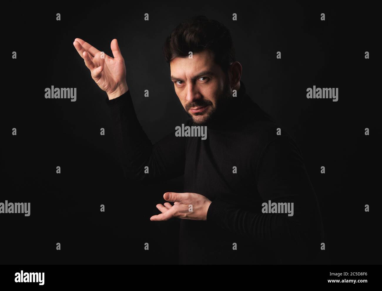 handsome bearded man posing over black studio background Stock Photo