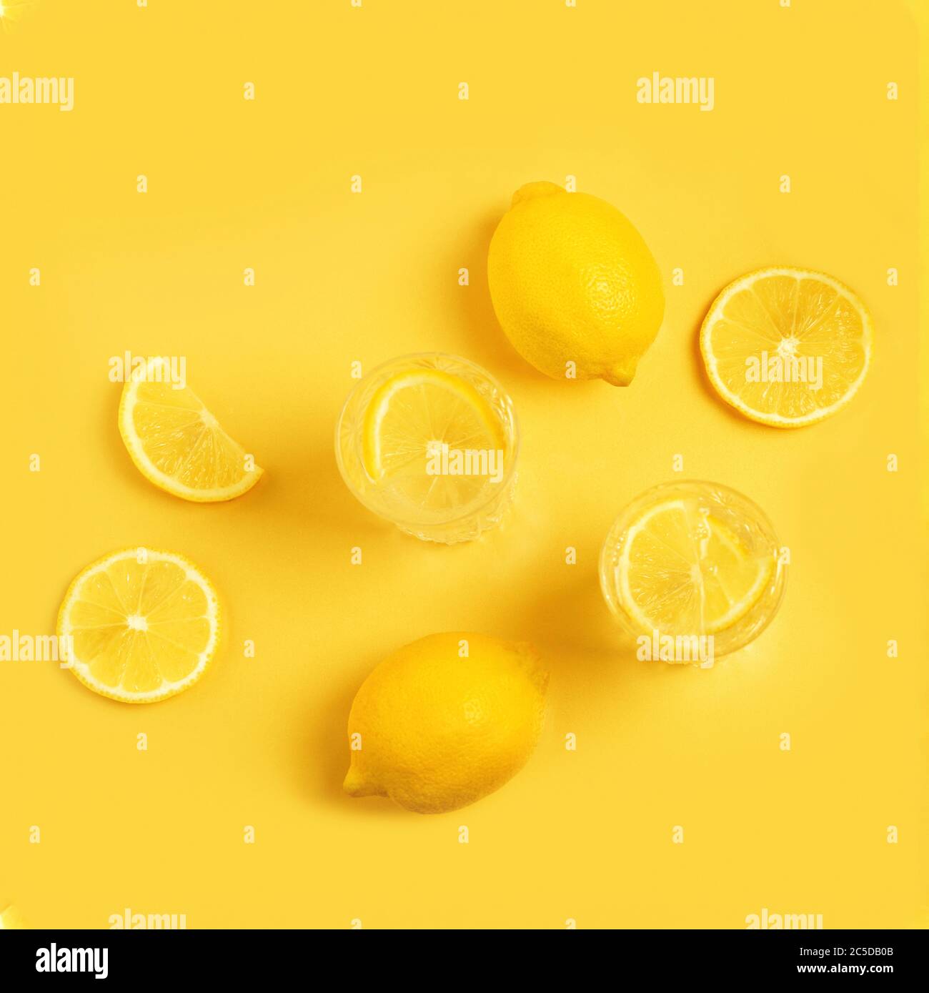 Detox with lemon on a yellow background. Citrus lemonade. In summer, fruits insisted on water.Fresh lemon - pattern. Flat lay. Stock Photo