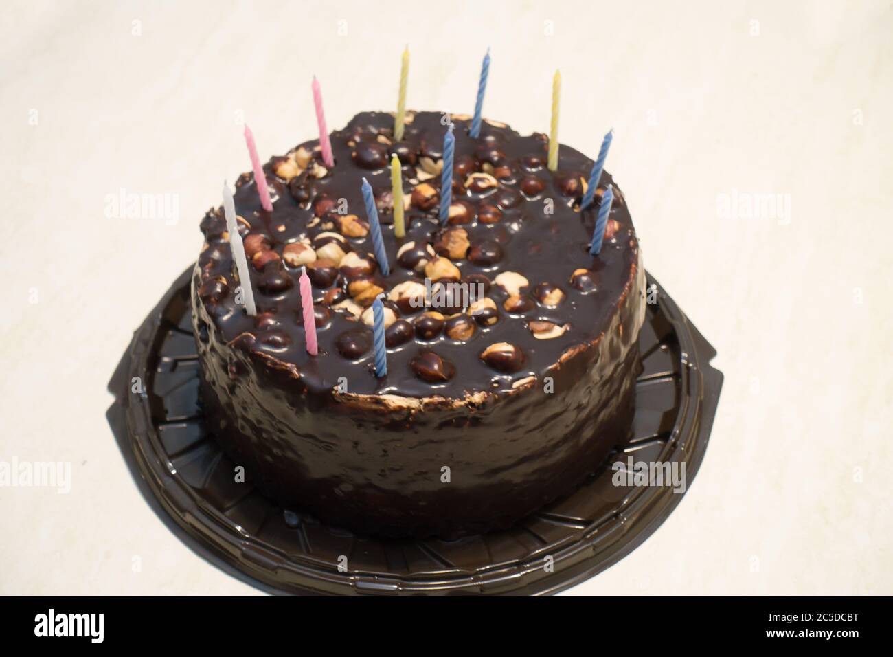 cake covered with chocolate with a few candles for a birthday party Stock Photo