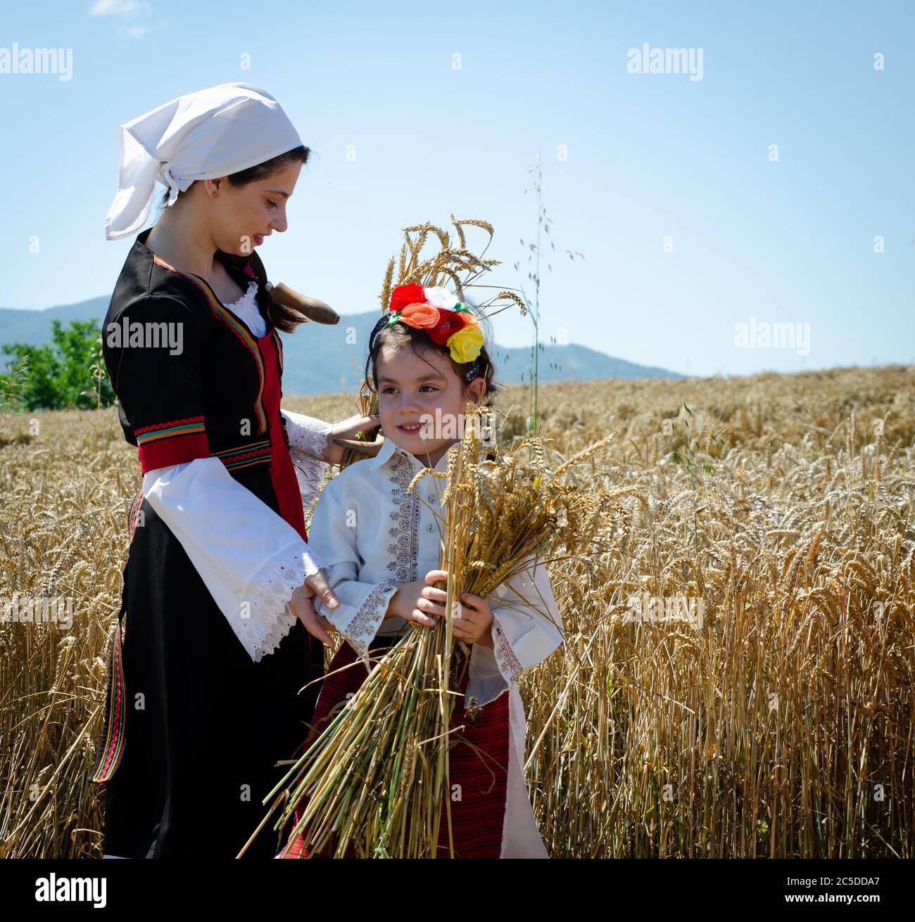 Young Bulgarian women in traditional costume celebrate the harvest festival harvest in countryside village. Stock Photo