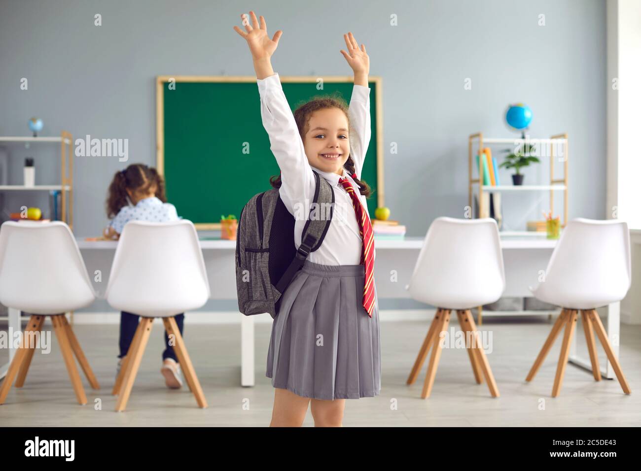 Concept back to school. Happy schoolgirl smiling raised her hands up ...