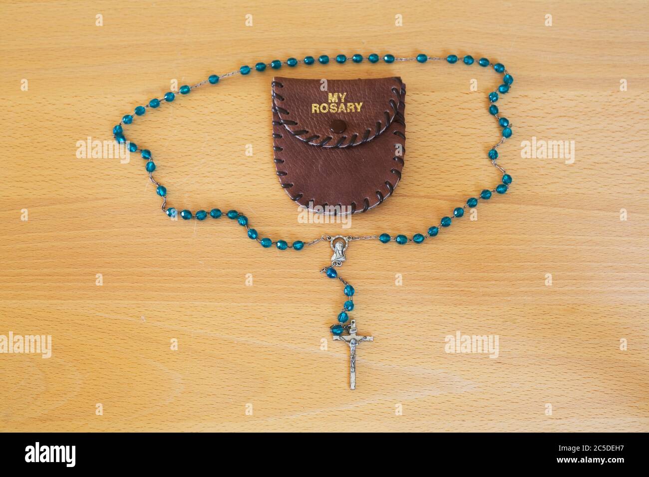 Blueish green rosary with 'my rosary' brown wallet Stock Photo