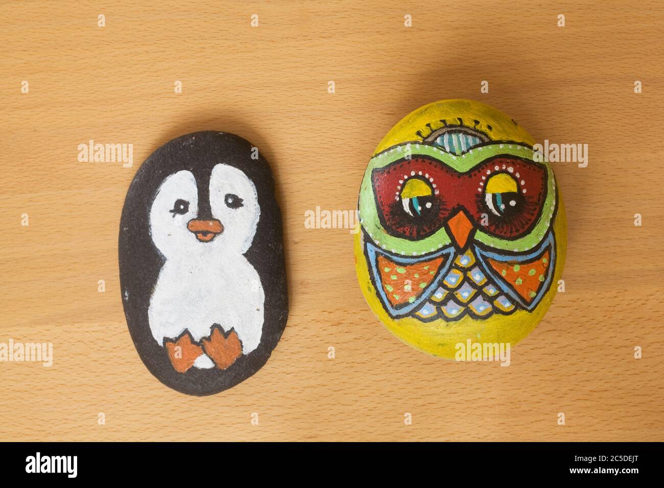 penguin and owl painted on beach pebbles as part of a school art project Stock Photo