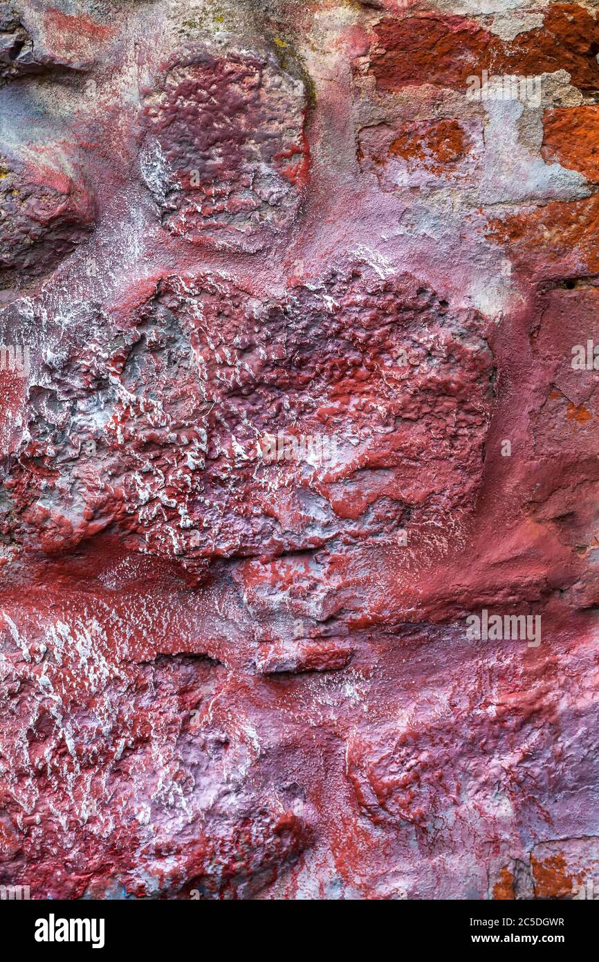 Old abstract red blue multi coloured painted stone brick wall texture background Stock Photo